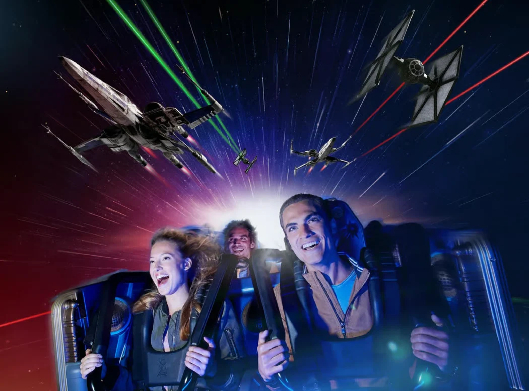 Guests riding Hyperspace Mountain roller coaster as Star Wars spaceships battle in a galaxy backdrop at Disneyland Paris