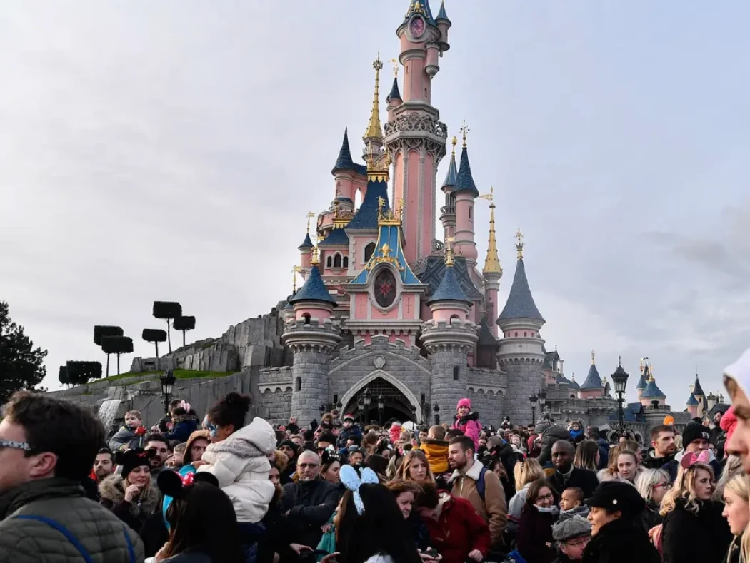Large crowd gathers in front of the Disneyland Paris castle on a busy day