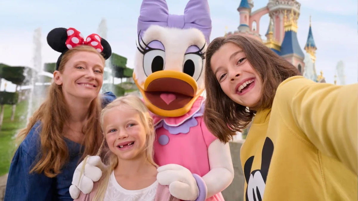 Family taking a selfie with Daisy Duck in front of the Disneyland Paris castle