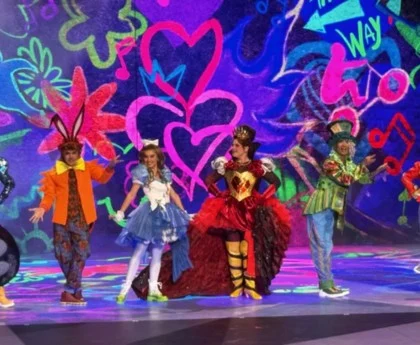 Performers dressed as Alice in Wonderland characters on stage