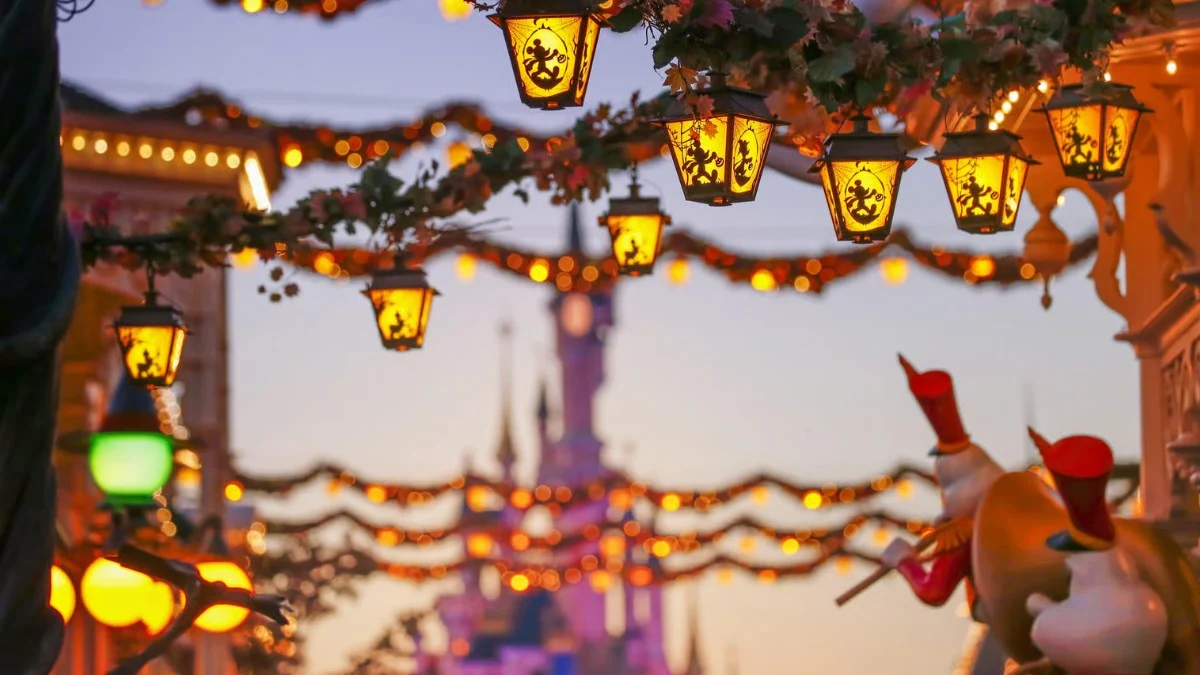 Golden lanterns glow above Main Street with the castle blurred