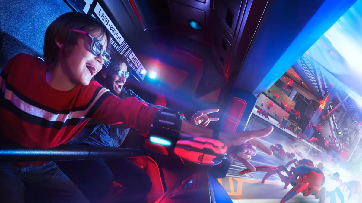A child and an adult in 3D glasses enjoy a 3D Spider-Man ride at Disneyland Paris