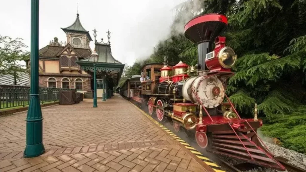 The Disneyland Paris steam train stops at a themed station with smoke rising