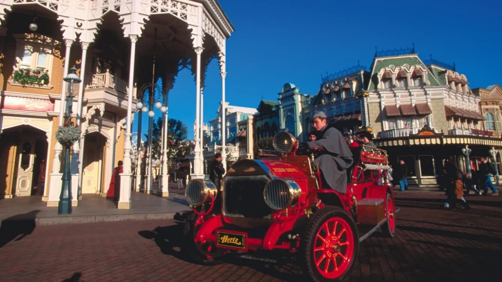 A vintage red fire truck drives along Main Street at Disneyland Paris