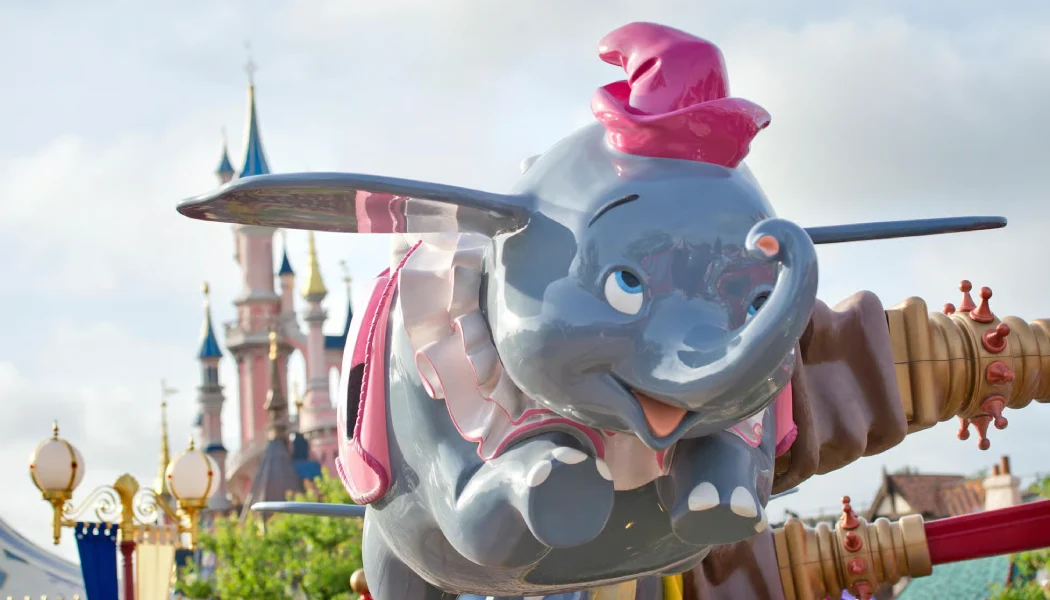 Dumbo the Flying Elephant ride soars with Sleeping Beauty Castle in background