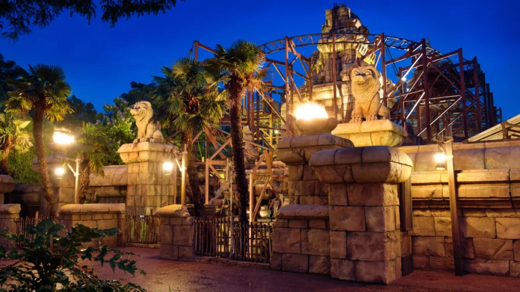 Entrance to Indiana Jones Temple of Peril roller coaster at Disneyland Paris lit up at night.
