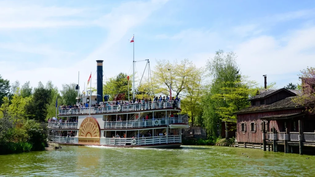 The Molly Brown riverboat sails on the lake at Disneyland Paris filled with visitors