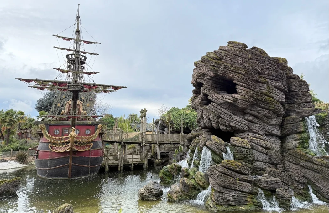 Pirate ship beside Skull Rock with waterfalls in Adventure Isle, Disneyland Paris